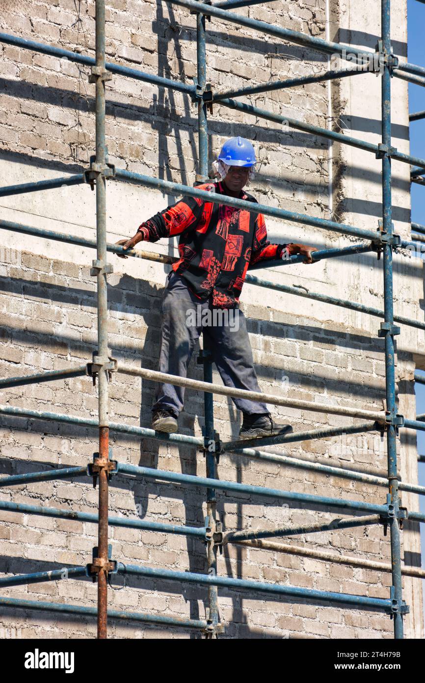 afroamerikaner kletterten auf das Gerüst einer Baustelle eines Geschäftsgebäudes Stockfoto