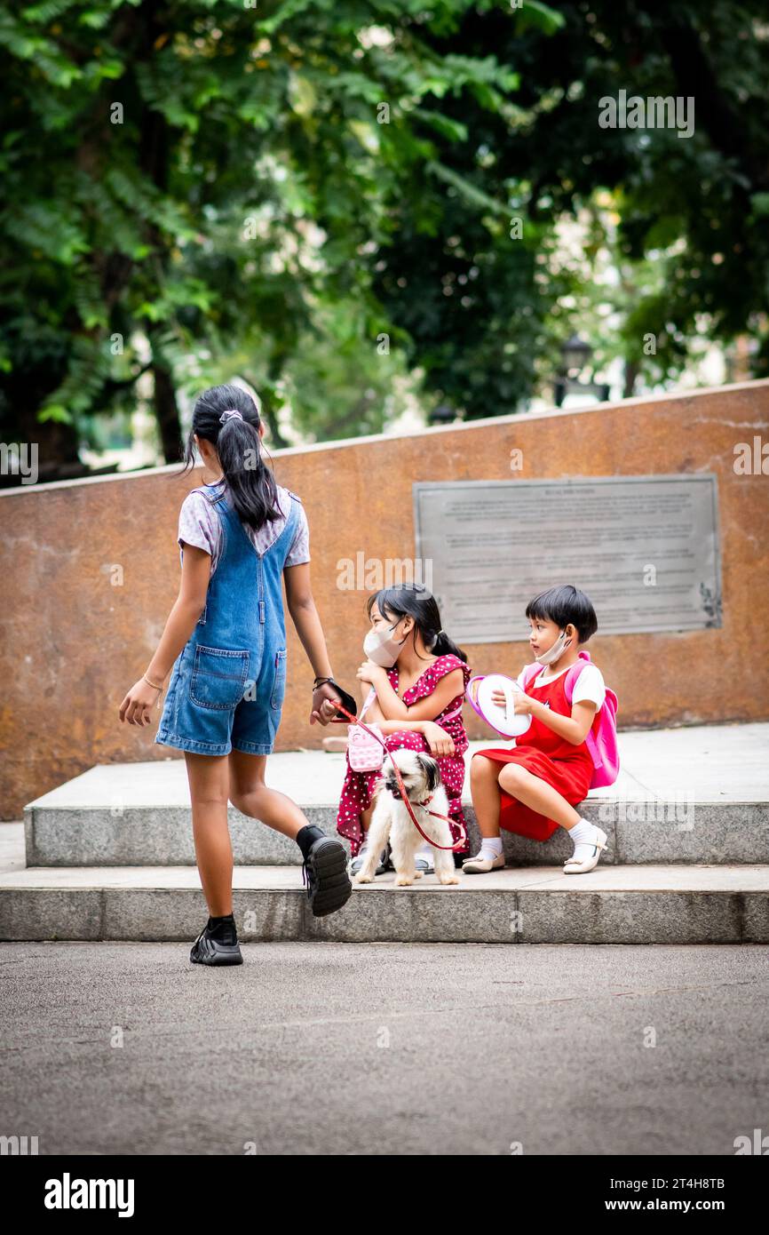 Kinder spielen um eine Statue im Rizal Park, Ermita, Manila, den Philippinen. Stockfoto