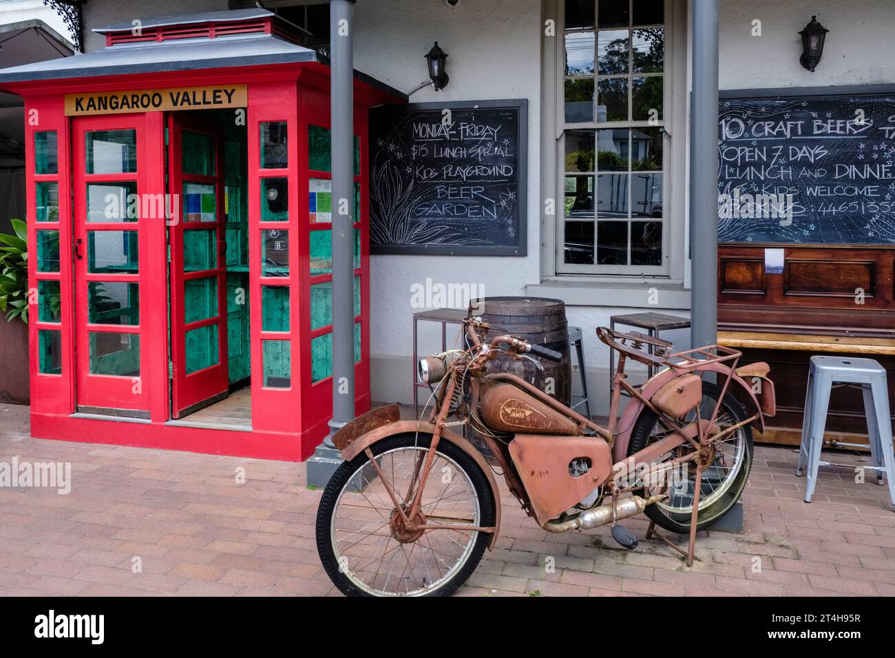 Ein altes Motorrad und eine alte Telefonbox vor dem Friendly Inn, Kangaroo Valley, New South Wales, Australien Stockfoto