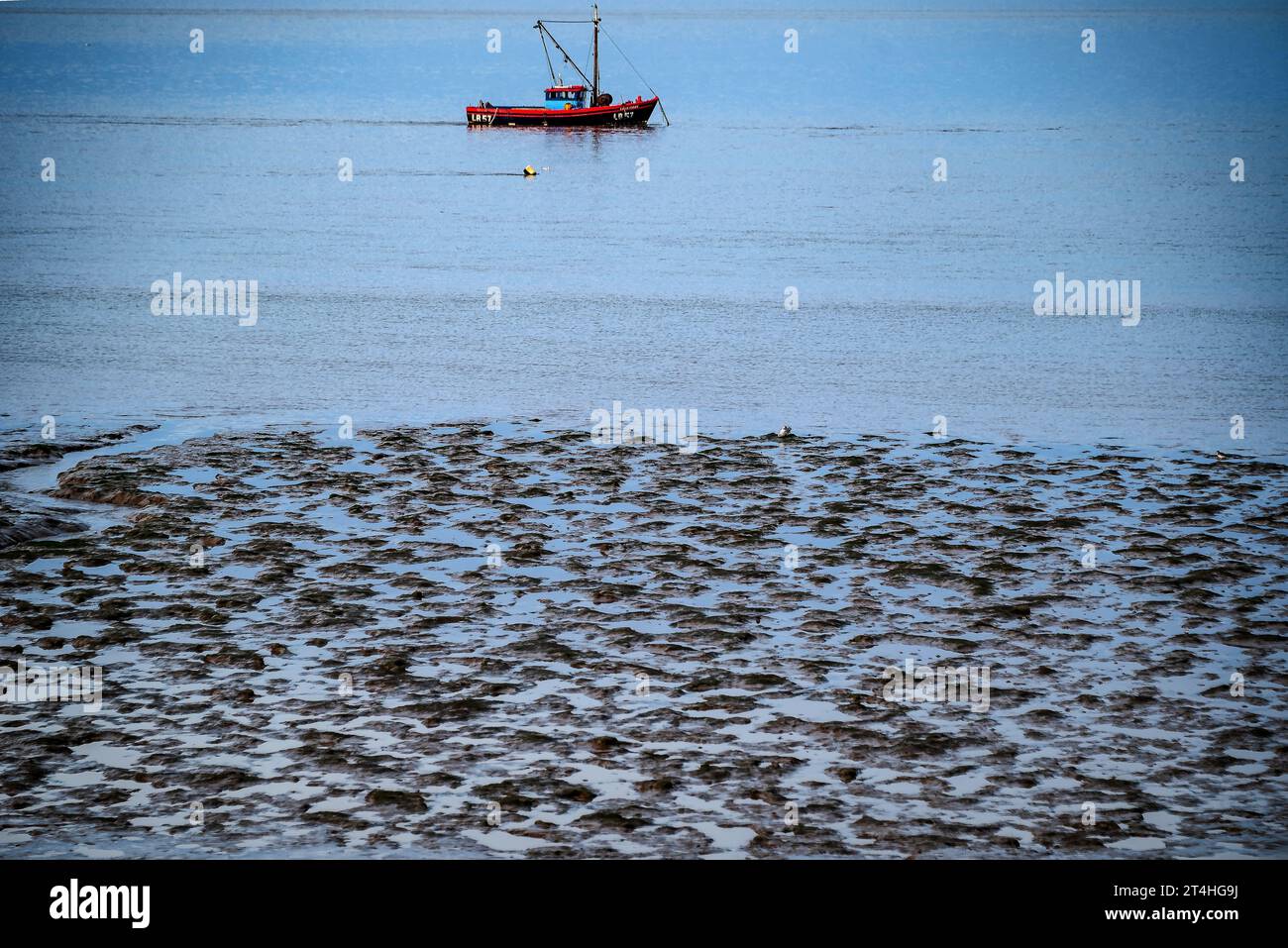 Morecambe Bay Herbst hellblaue Stunde. Fischerboot vor Anker. Stockfoto