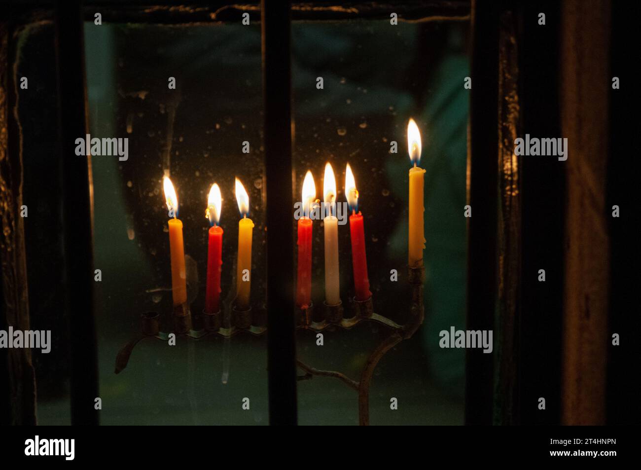 Mehrfarbige Hanukka-Kerzen brennen in einer Menora während der Feier des jüdischen Lichterfestes. Stockfoto
