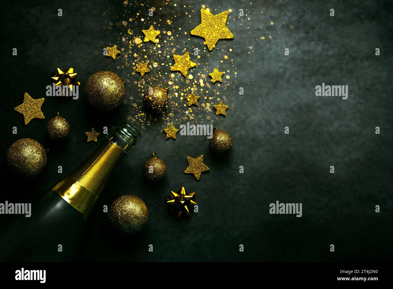 Hintergrund des Weihnachtskonzepts. Sektflasche, weihnachtskugeln und glitzernder Glitzer mit Platz für Text auf grauem Hintergrund. Eve-Feier-Konzept b Stockfoto