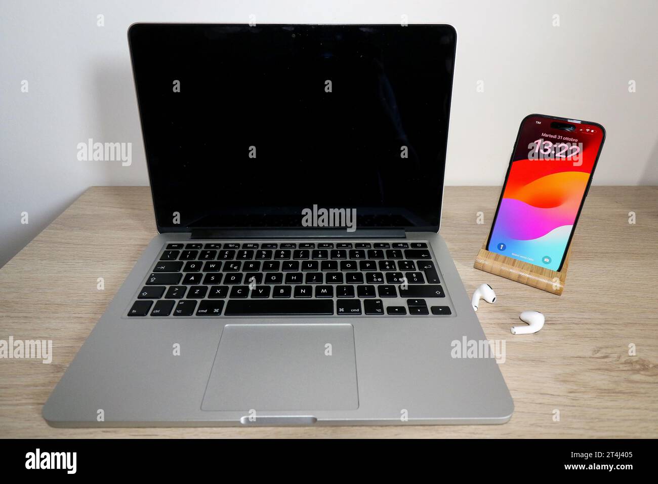 Apple MacBook Pro mit iPhone 15 Pro und AirPods Stockfoto