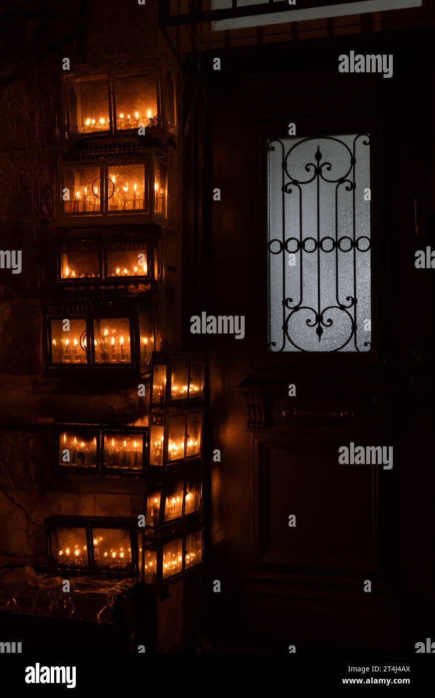 Glühende Hanukkah-Menorahs, beleuchtet mit kleinen Röhrchen mit Ölbrand in einem schützenden Glasgehäuse außerhalb eines Wohngebäudes in Jerusalem während der Feierlichkeiten Stockfoto