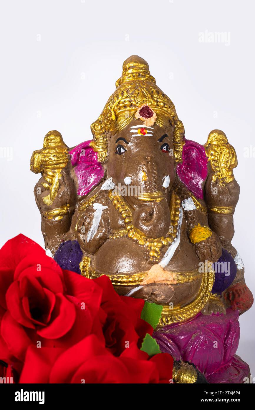 Ganesh Idol aus Ton mit Blume auf weißem Hintergrund. Stockfoto
