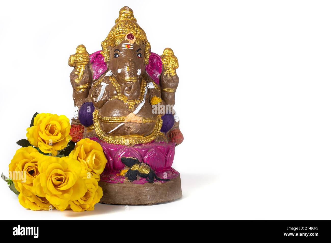 Vinayaka Chaturthi - Ganesh-Statue aus Ton mit gelben Blumen auf weißem Hintergrund. Stockfoto