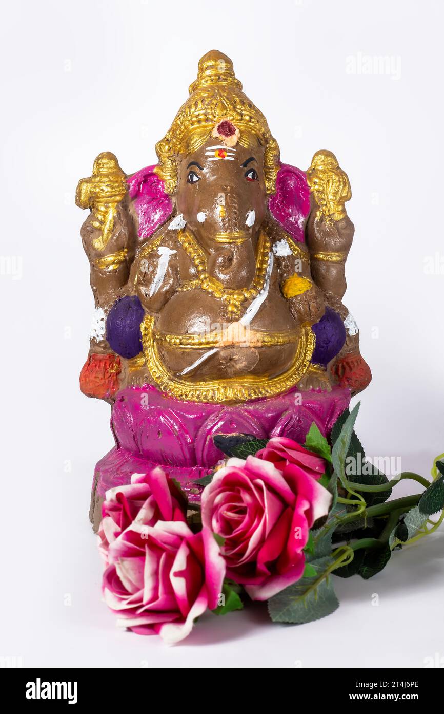 Happy Ganesh Chaturthi - indischer Hindugott Lord Ganesh Statue aus Lehm mit Blumen auf weißem Hintergrund. Stockfoto