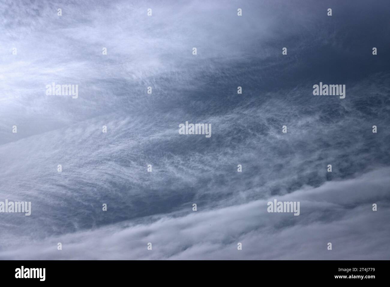 Ein weicher, milchiger Schleier des Cirrostratus hat eine Struktur, die durch Winde in großer Höhe geschaffen wurde. Diese Formationen produzieren keinen Regen, sondern sind umfangreich. Stockfoto