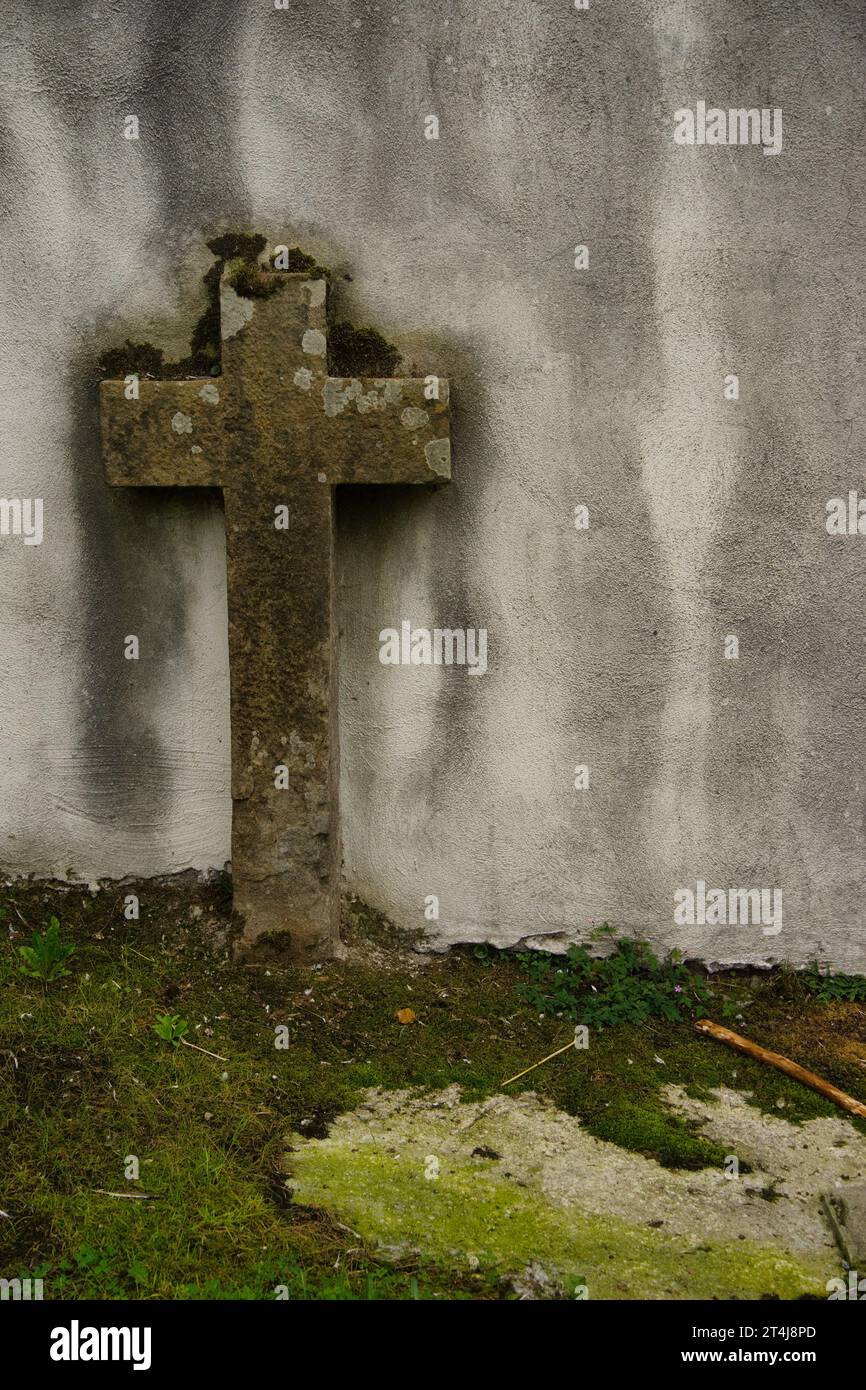 Steinkreuz auf einer alten Mauer, schafft eine geheimnisvolle Atmosphäre. Geeignet für jedes Projekt, das Mystery, Einsamkeit, Distress, Angst, Zombies, Tod, o Stockfoto