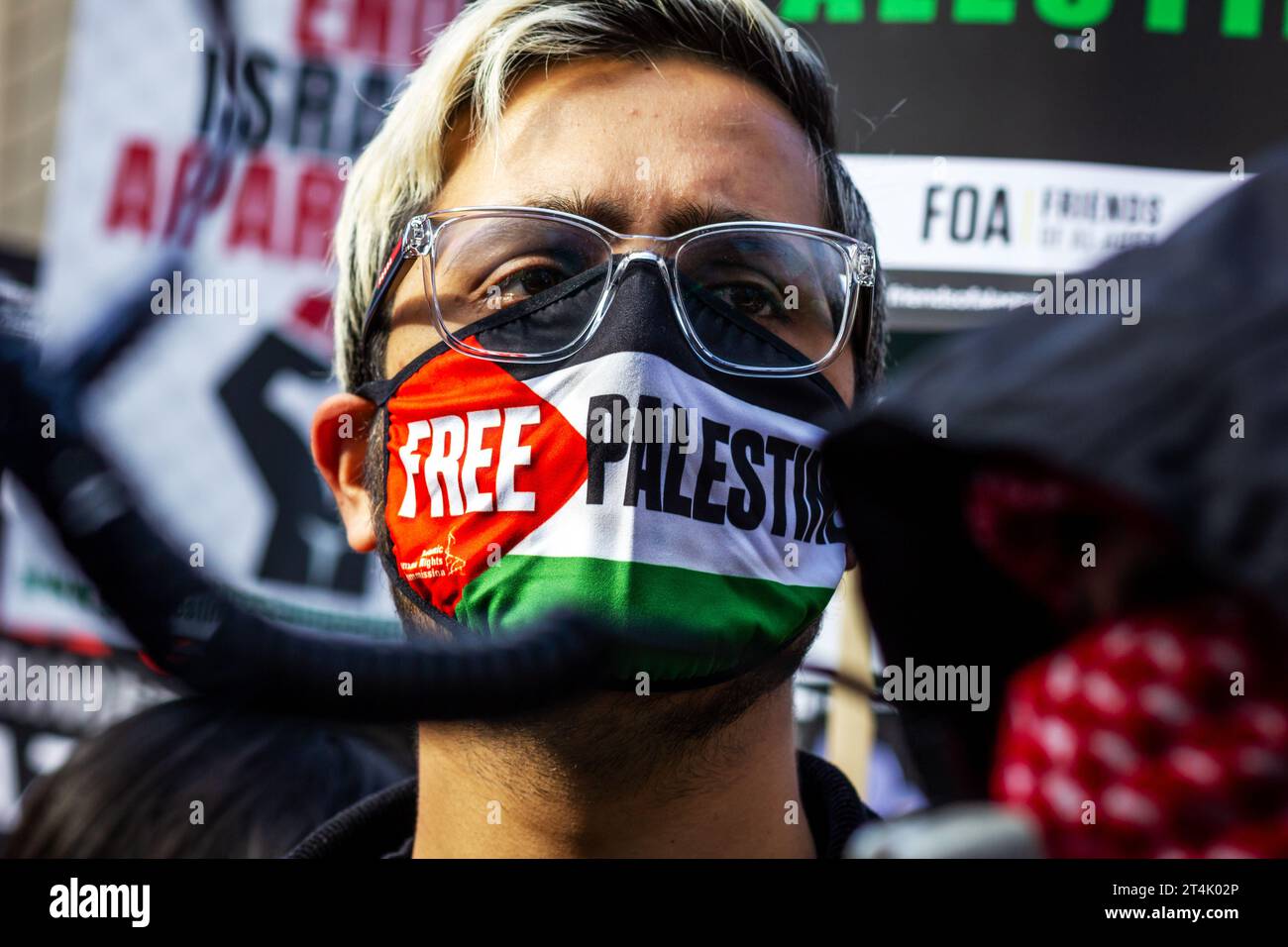 Ein Mann, der eine Gesichtsmaske des Freien Palästinas trägt, während eines Protestes in Solidarität mit Palästinensern in Gaza, Zentral-London. Stockfoto
