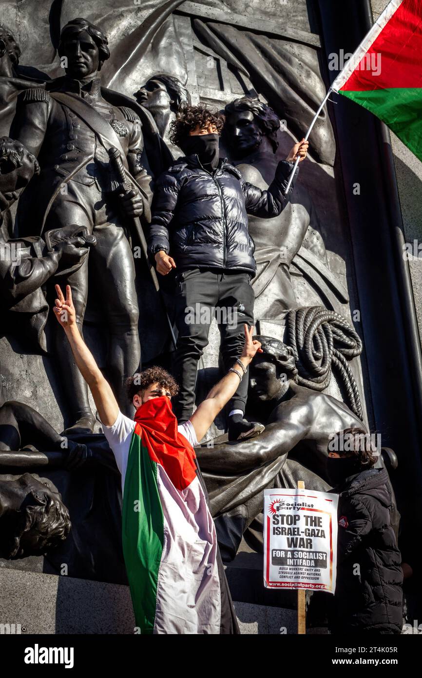 Während der propalästinensischen Demonstration auf dem Trafalgar-Platz hält ein Demonstrant die Flagge Palästinas hoch Stockfoto