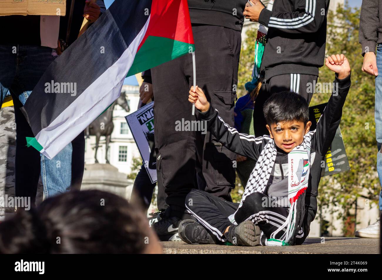 Ein Kind hält während der pro-palästinensischen Demonstration auf dem Trafalgar-Platz die Flagge Palästinas hoch Stockfoto