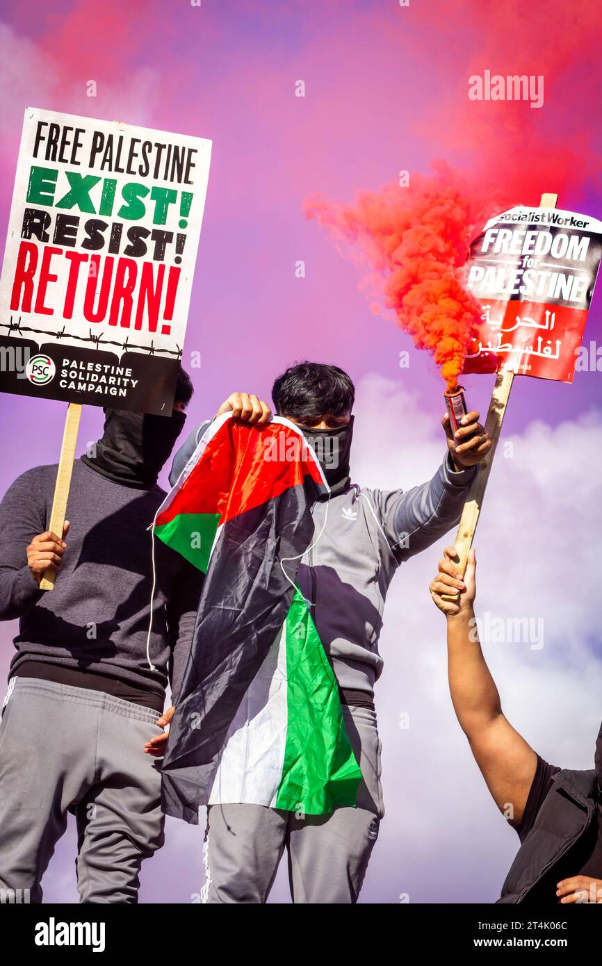 Die Demonstranten halten die Flagge Palästinas und eine Fackel während der pro-palästinensischen Demonstration auf dem Trafalgar-Platz hoch Stockfoto