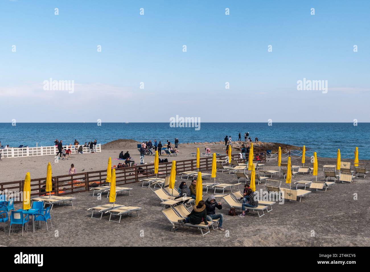 Nebensaison Blick auf den Strand des beliebten Urlaubsziels an der PalmenRiviera mit Menschen im Frühling, Loano, Savona, Ligurien, Italien Stockfoto