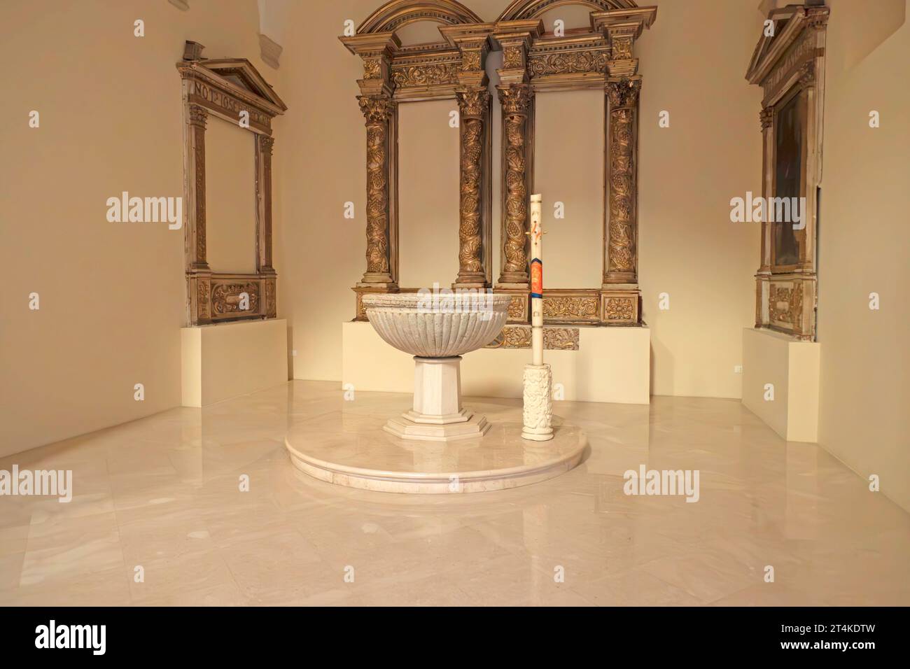 Taufbecken in der Pfarrkirche St. Antonius (Parrocchia Sant’Antonio) in Monopoli, Italien, vor kunstvollen klassischen Altarrahmen. Stockfoto