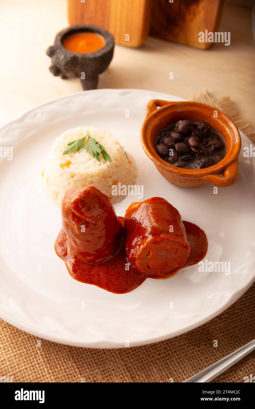 Fleischbrötchen mit Adobo, gefüllt mit Käse, Gemüse oder anderen Zutaten, serviert mit Reis und Bohnen, in Mexiko auch Wrapped Child oder genannt Stockfoto