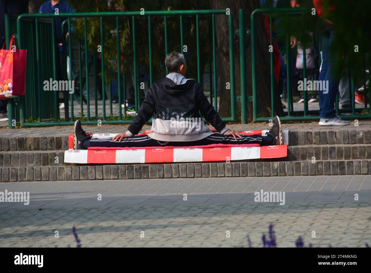 Ein älterer Mann, der die Spaltung im Park in Peking, China, macht. Stockfoto