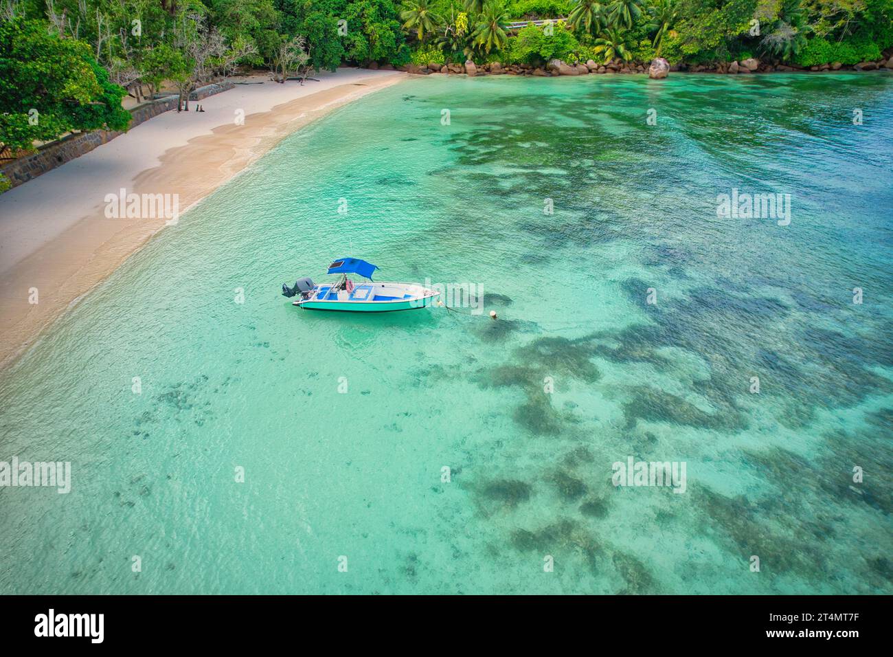 Drohne am Strand von baie lazare, Andocken des Fischerbootes bei Ebbe nahe der Küste, türkisfarbenes Wasser, sonniger Tag, Mahe Seychellen Stockfoto