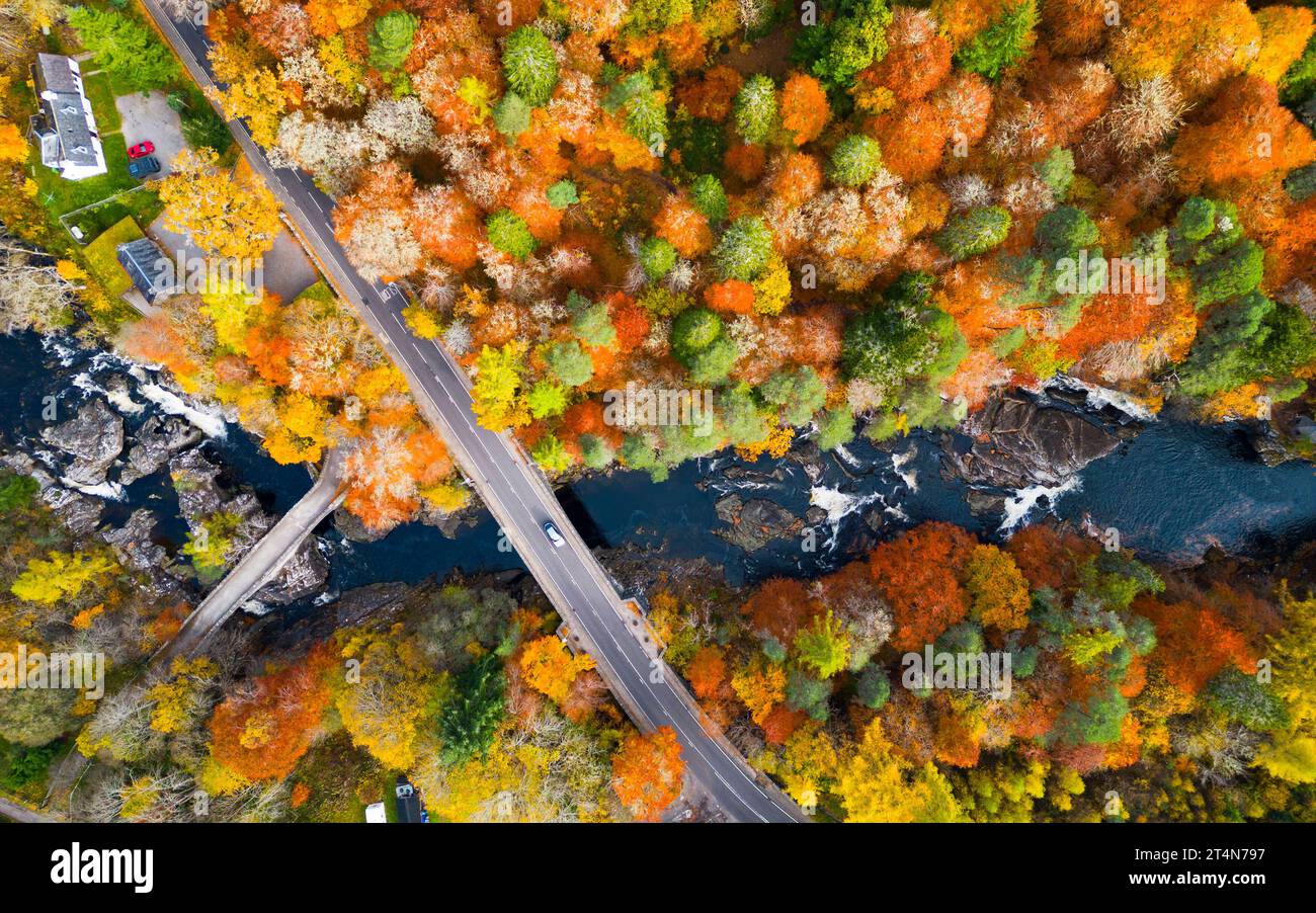 Blick aus der Vogelperspektive auf alte und neue Brücken, die den Fluss Moriston überqueren, umgeben von Wäldern in Herbstfarben in Invermoriston, Schottland, Großbritannien Stockfoto