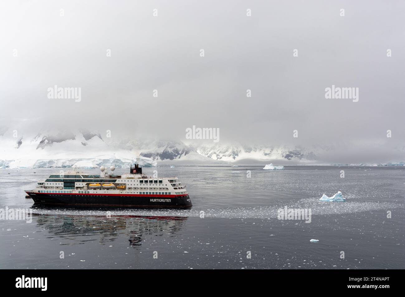 hurtigruten-Kreuzfahrtschiff und Zodiacs in eiskalten Gewässern der charlotte Bay an der danco-Küste. antarktische Halbinsel. antarktis Stockfoto