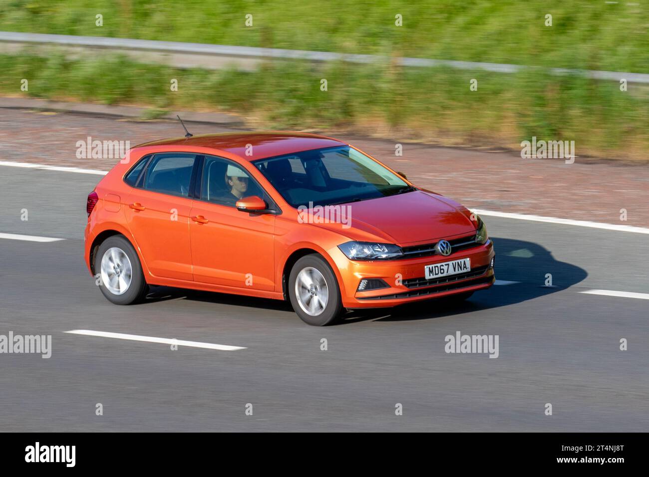 VW Volkswagen Polo SE TSI 95 Start/Stop Orange Car Hatchback Benzinmotor 999 ccm; Fahrt auf der Autobahn M6 im Großraum Manchester, Großbritannien Stockfoto