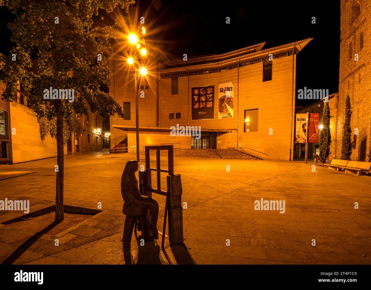 Fassade des Bischofsmuseums von Vic (MEV) bei Nacht. Davor eine Skulptur von Fernando Bravo (Vic, Osona, Barcelona, Katalonien, Spanien) Stockfoto