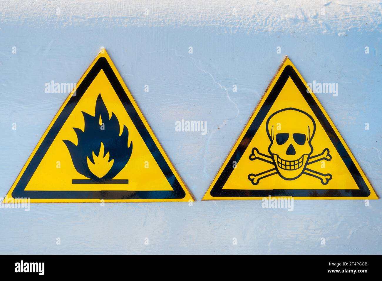 Gefahrenwarnschilder. Zwei gelbe Dreiecke. Schädel und Knochen. Feuer. Achtung: Explosiv. Vorsicht vor Gift. Stockfoto
