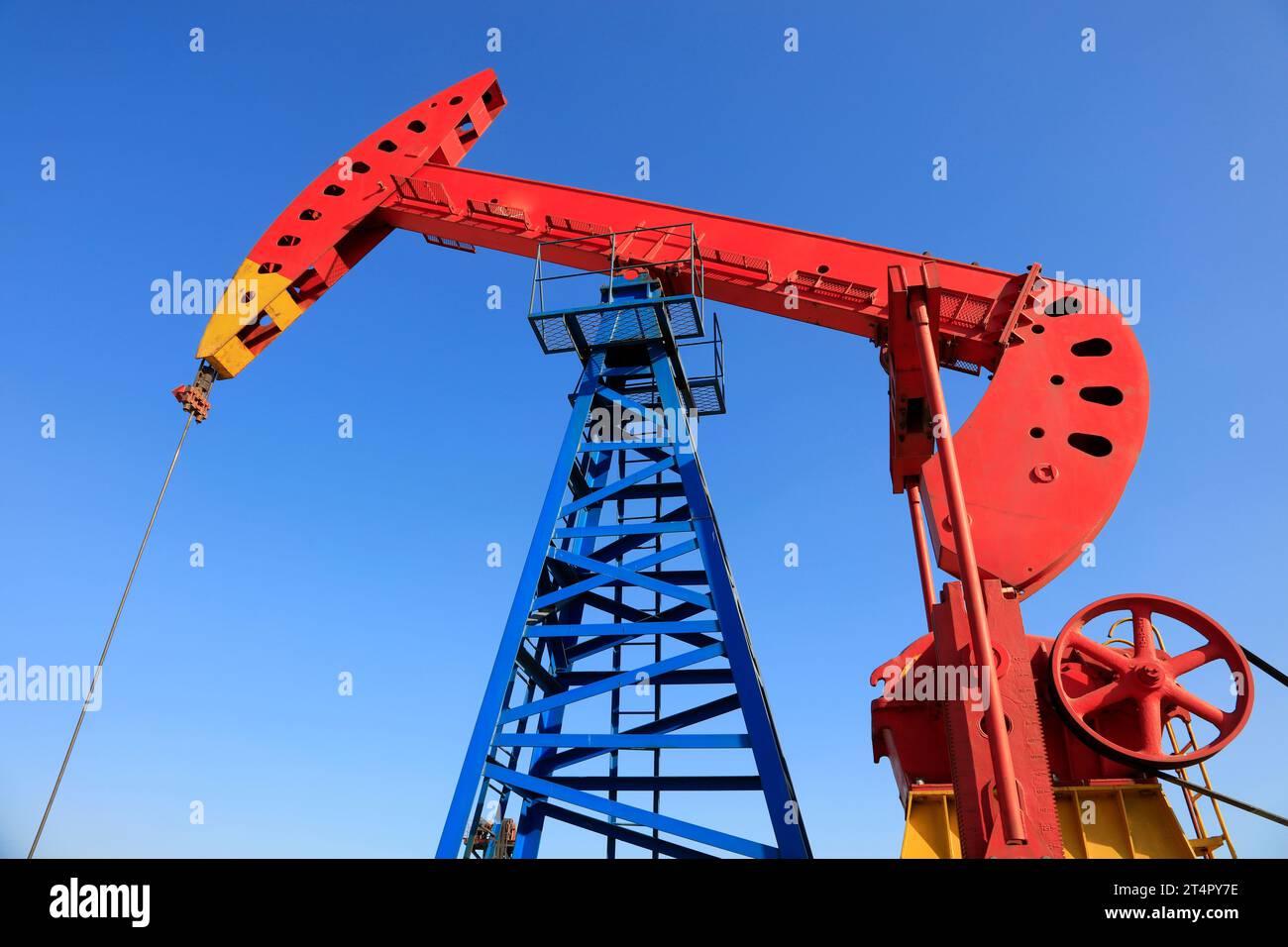 Pumpenaggregat-Laufbalken unter blauem Himmel im Ölfeld Stockfoto