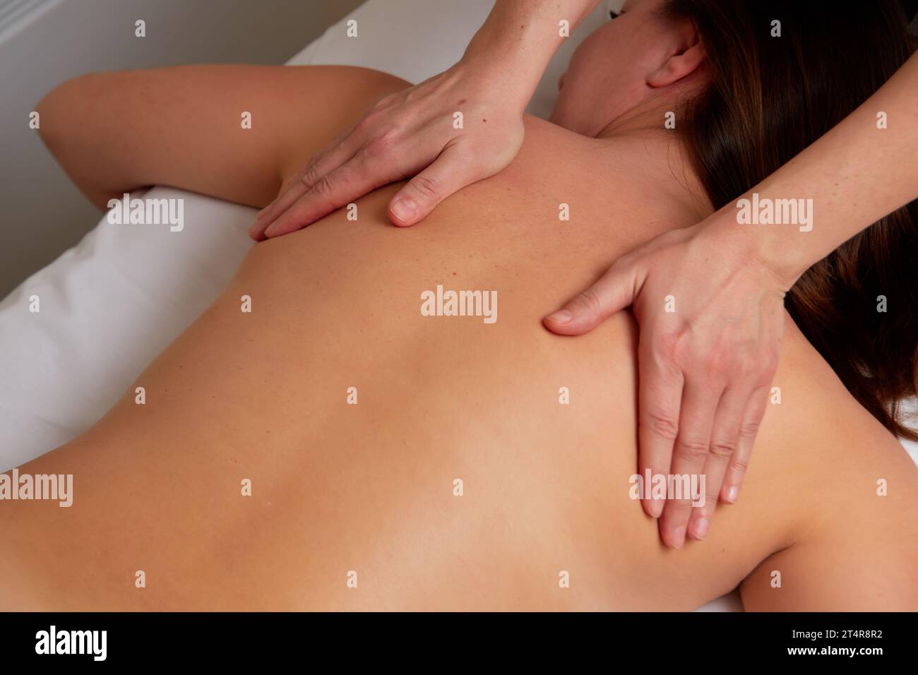 Professionelle Massage-Therapeutin, die junge Frau im Spa-Salon entspannende Rückenmassage anbietet. Stockfoto
