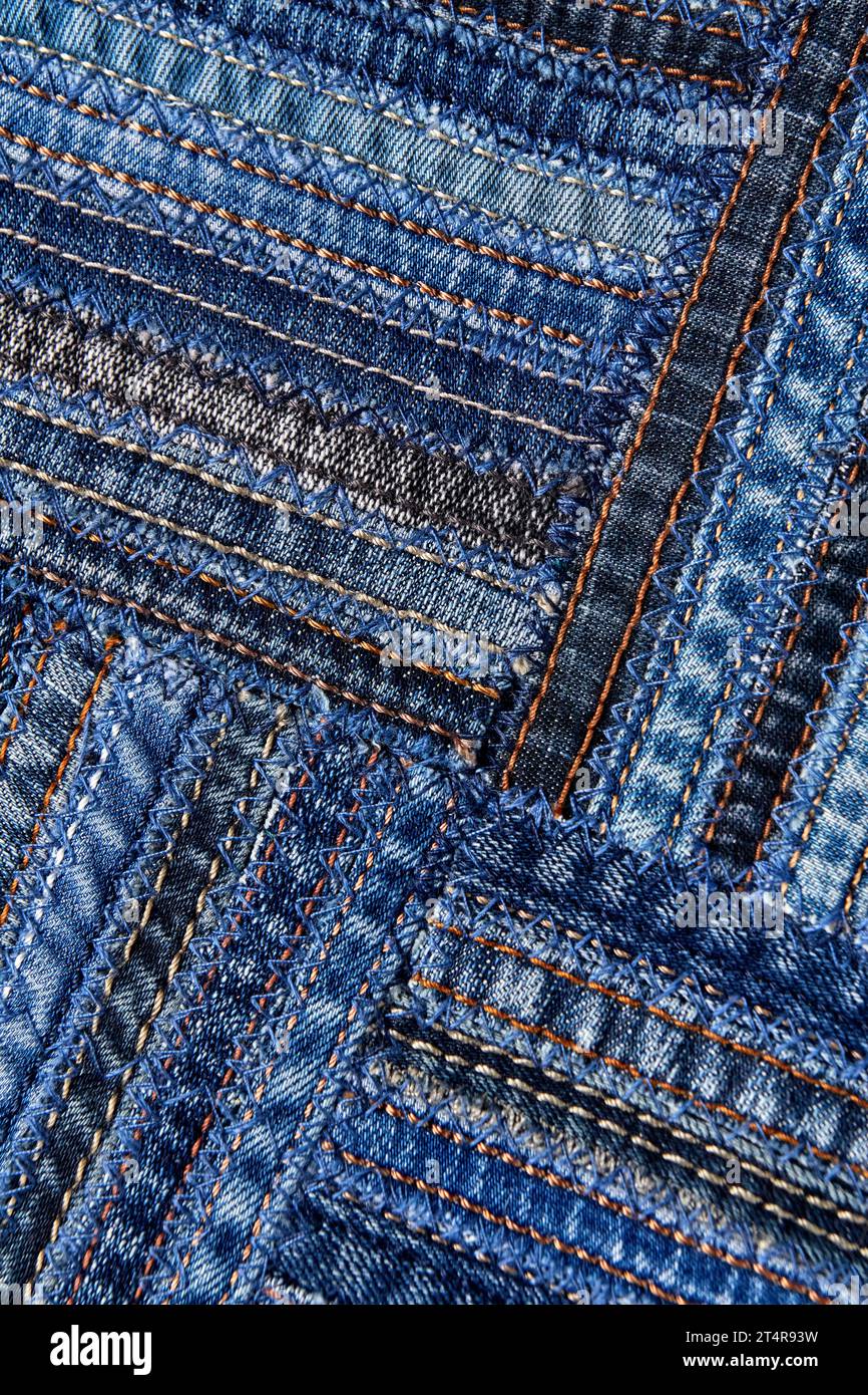 Diagonales Denim-Muster im Patchwork-Stil aus Nähten alter Jeans. Stockfoto