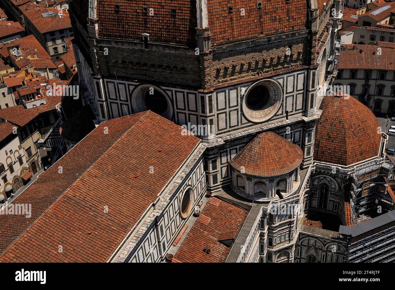 Duomo di Firenze, Toskana, Italien: Rote Ziegeldächer und Fußwege, zusammen mit Okuli und weißem Marmor. Oben auf dem Bild befindet sich die raue Ziegelbasis auf sieben Seiten der achteckigen Kuppel der Kathedrale, unter den Terrakottafliesen und Rippen aus weißem Marmor. 1507 begann Baccio d’Agnolo (1462–1543) mit dem Anbau eines Balkons an der Basis der Kuppel; 1515, als jedoch nur an einer der acht Seiten der Kuppel ein Balkon hinzugefügt wurde, verhöhnte Michelangelo das Aussehen des Balkons und die Arbeit wurde gestoppt. Stockfoto