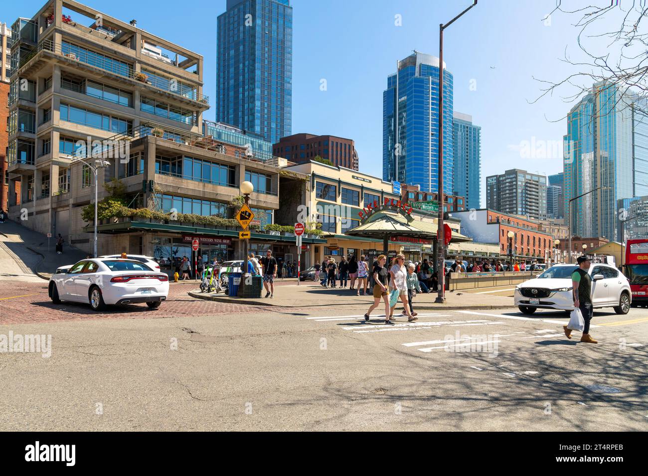Fußgänger genießen einen sonnigen Tag am Pike Place Eingang zu der beliebten Touristenattraktion entlang des Hafenviertels, Seattle Washington. Stockfoto