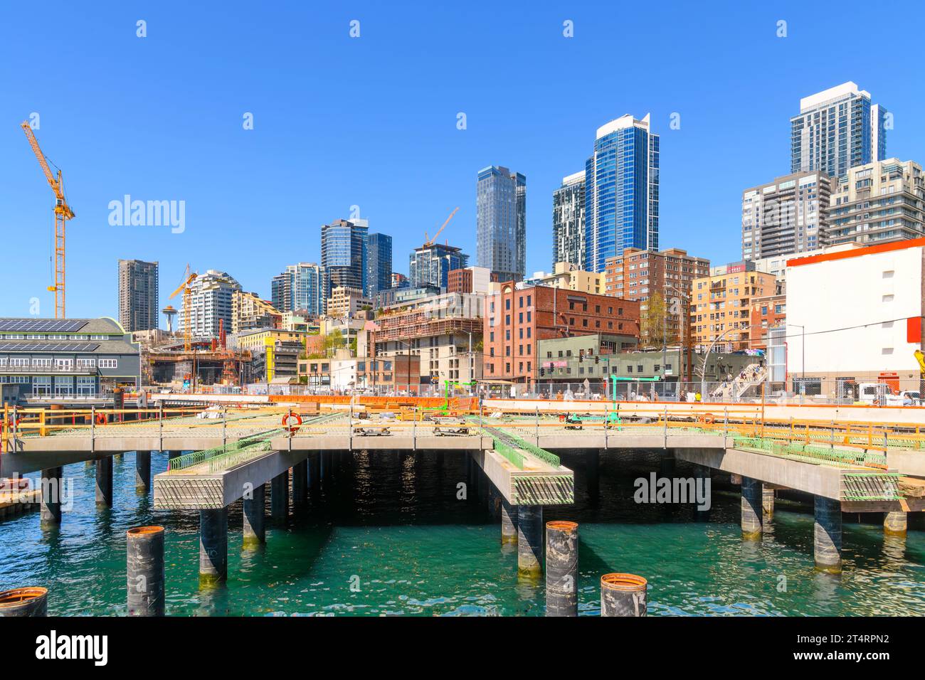 Baukräne und Arbeiten an der Innenstadt von Seattle Waterfront und dem Kreuzfahrthafen entlang des Alaska Way, mit Blick auf die Skyline der Stadt und das Aquarium Stockfoto