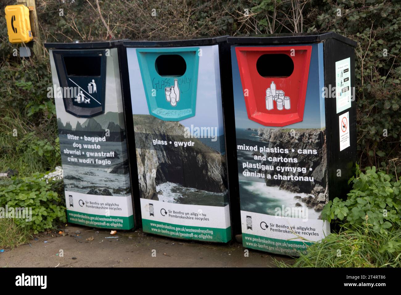 Drei farbenfrohe Recyclingbehälter für verpackte Dosenabfälle aus Glas gemischte Kunststoffdosen und Kartons entlang des Küstenweges Pembrokeshire National Park West Wale Stockfoto