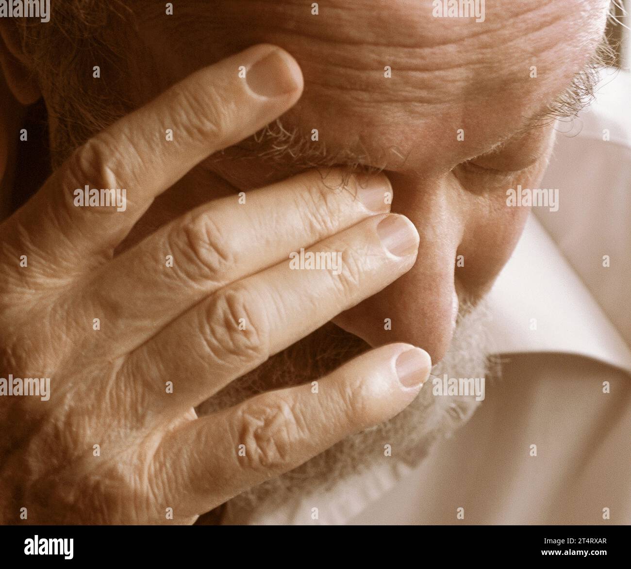 Nahaufnahme eines älteren Mannes, der sich die Augen reibt und nach unten blickt. Unsicherheit, festverzinsliche Einkommen, Traurigkeit, gesundheitliche und finanzielle Sorgen. Innenraum USA Stockfoto