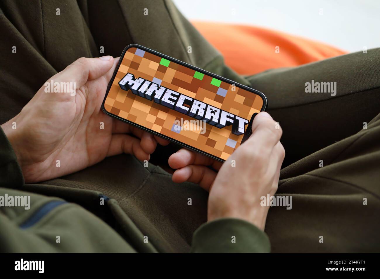 Minecraft mobiles iOS-Spiel auf dem iPhone 15 Smartphone-Bildschirm in männlichen Händen während des mobilen Gameplays. Mobiles Gaming und Entertainment auf einem tragbaren Gerät Stockfoto