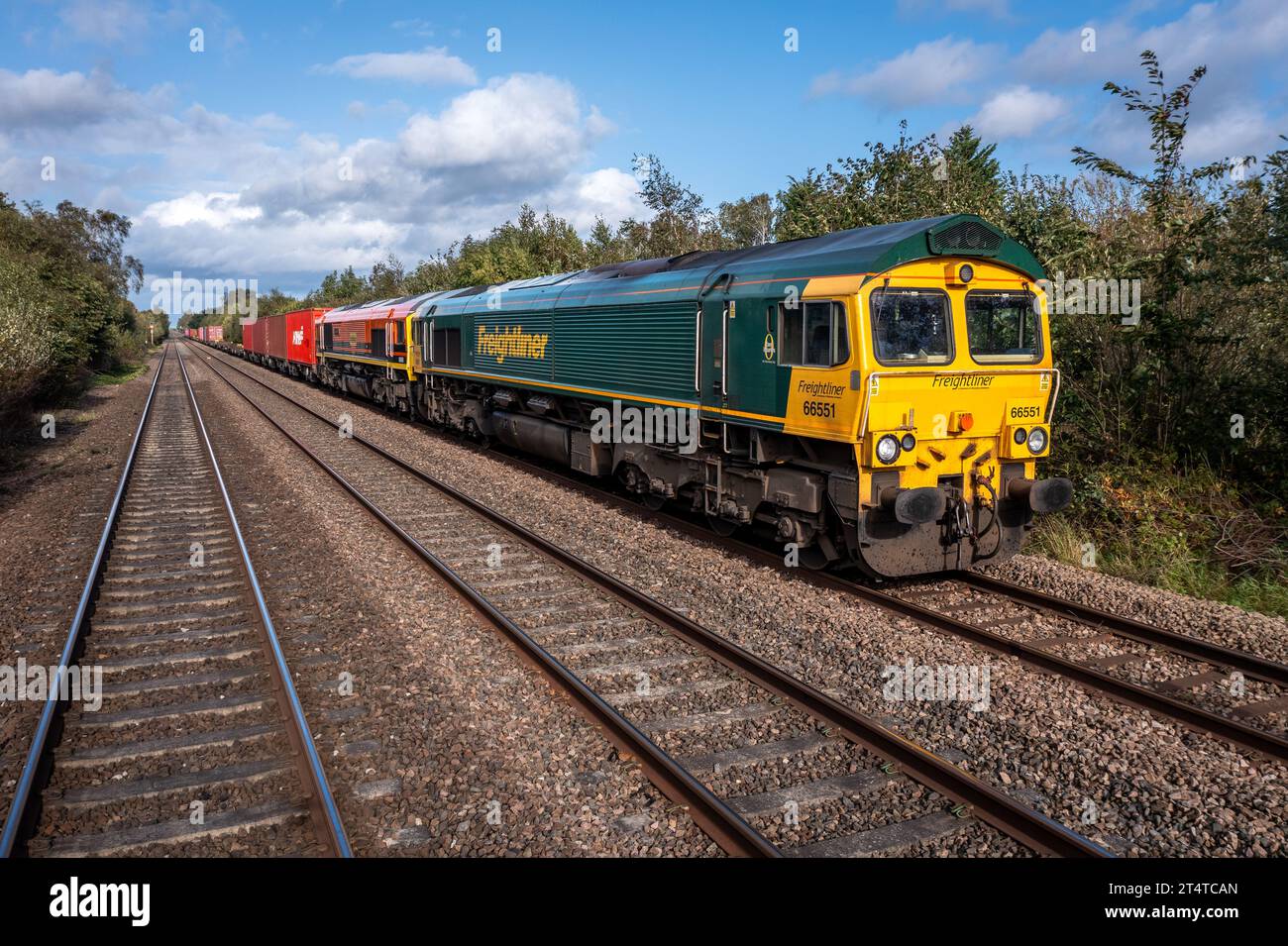 BURTON UPON TRENT, GROSSBRITANNIEN - 3. OKTOBER 2023. Zwei Freightliner Intermodal-Güterlokomotiven der Baureihe 66 schleppen einen Container-Containerzug auf dem Land Stockfoto