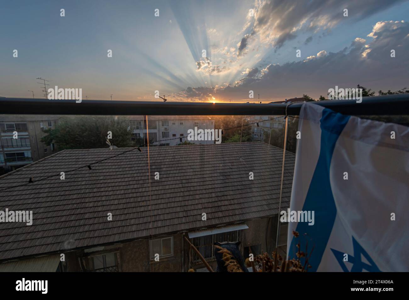 Hochauflösendes Panorama-Weitwinkelbild einer städtischen Umgebung mit einem wunderschönen Sonnenuntergang im Hintergrund mit einer israelischen Flagge Stockfoto
