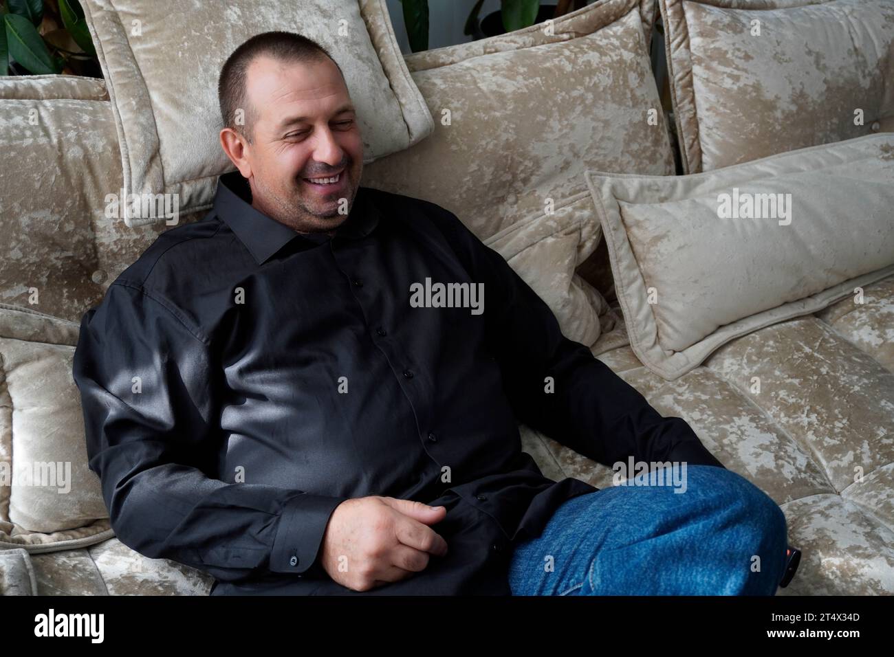 Mann sitzt auf dem Sofa und schaut fern Stockfoto