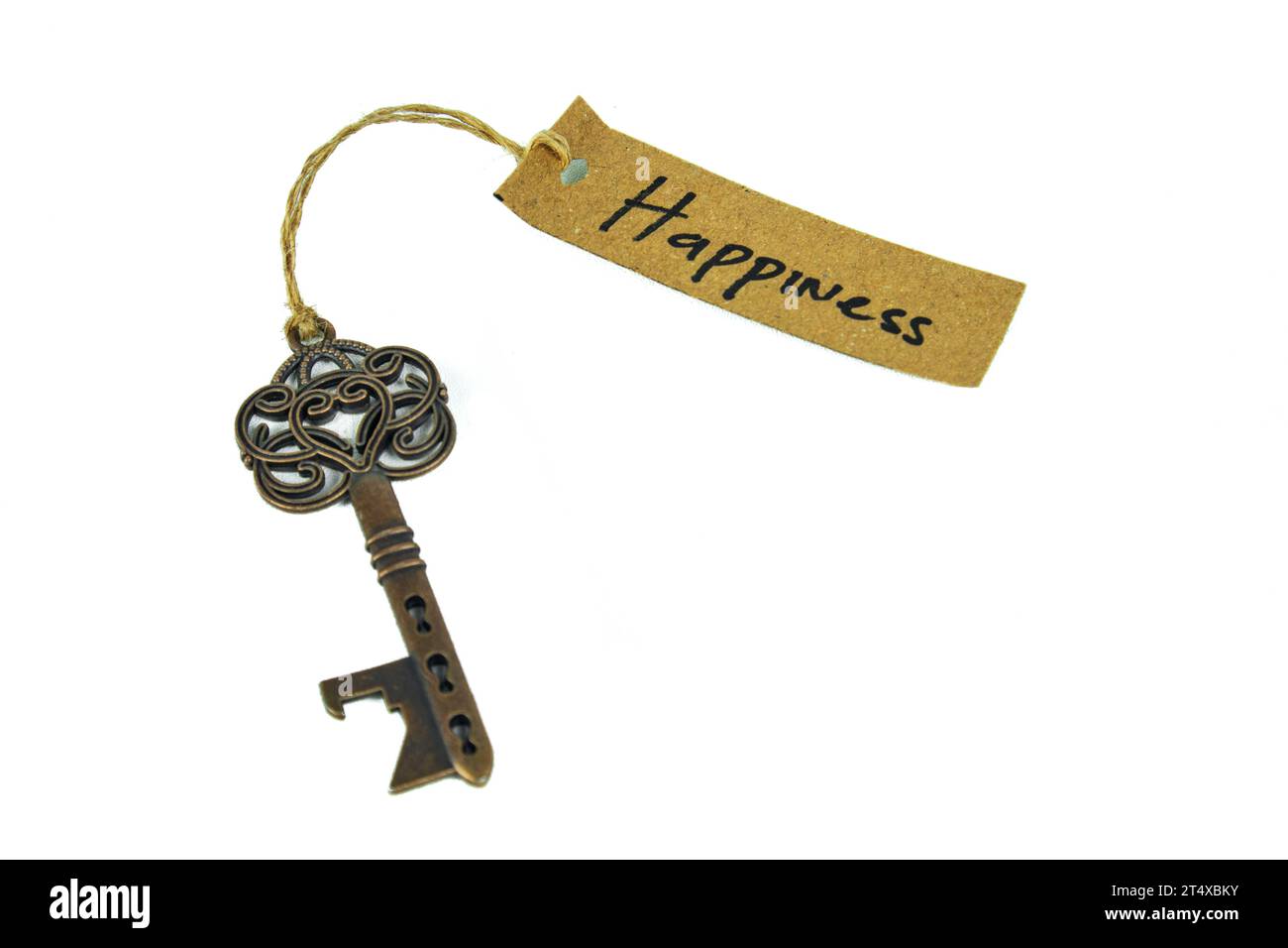 Alter dekorativer Schlüssel und handgeschriebenes Etikett „Happiness“, gebunden mit Strohseil auf weißem Hintergrund Stockfoto