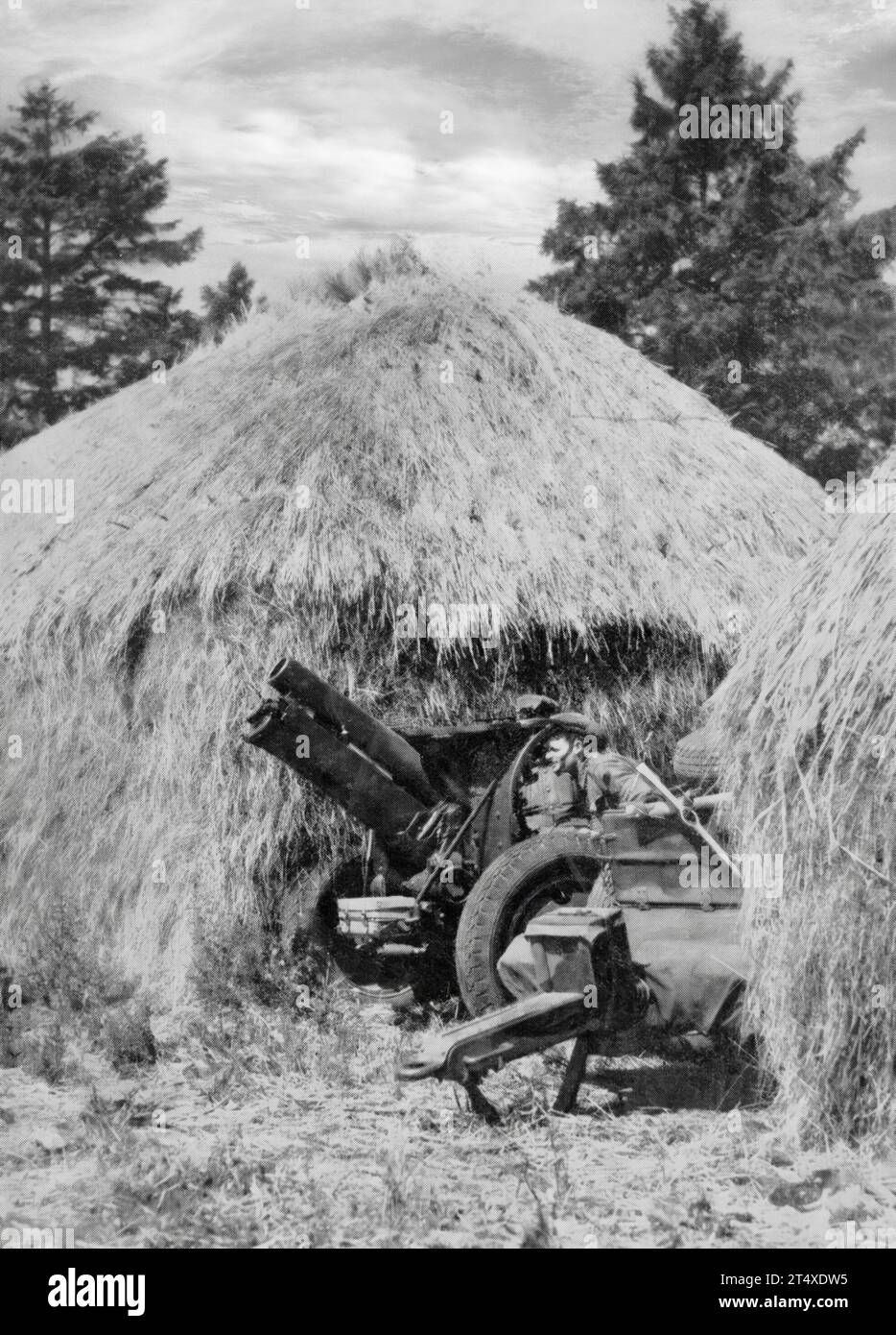 Eine große Anzahl australischer Truppen traf im Sommer 1940 in England ein. Dort, um das Land während der Angst vor einer deutschen Invasion zu schützen, verwenden australische Truppen Heuhaufen, um ihre Haubitzen zu tarnen. Stockfoto