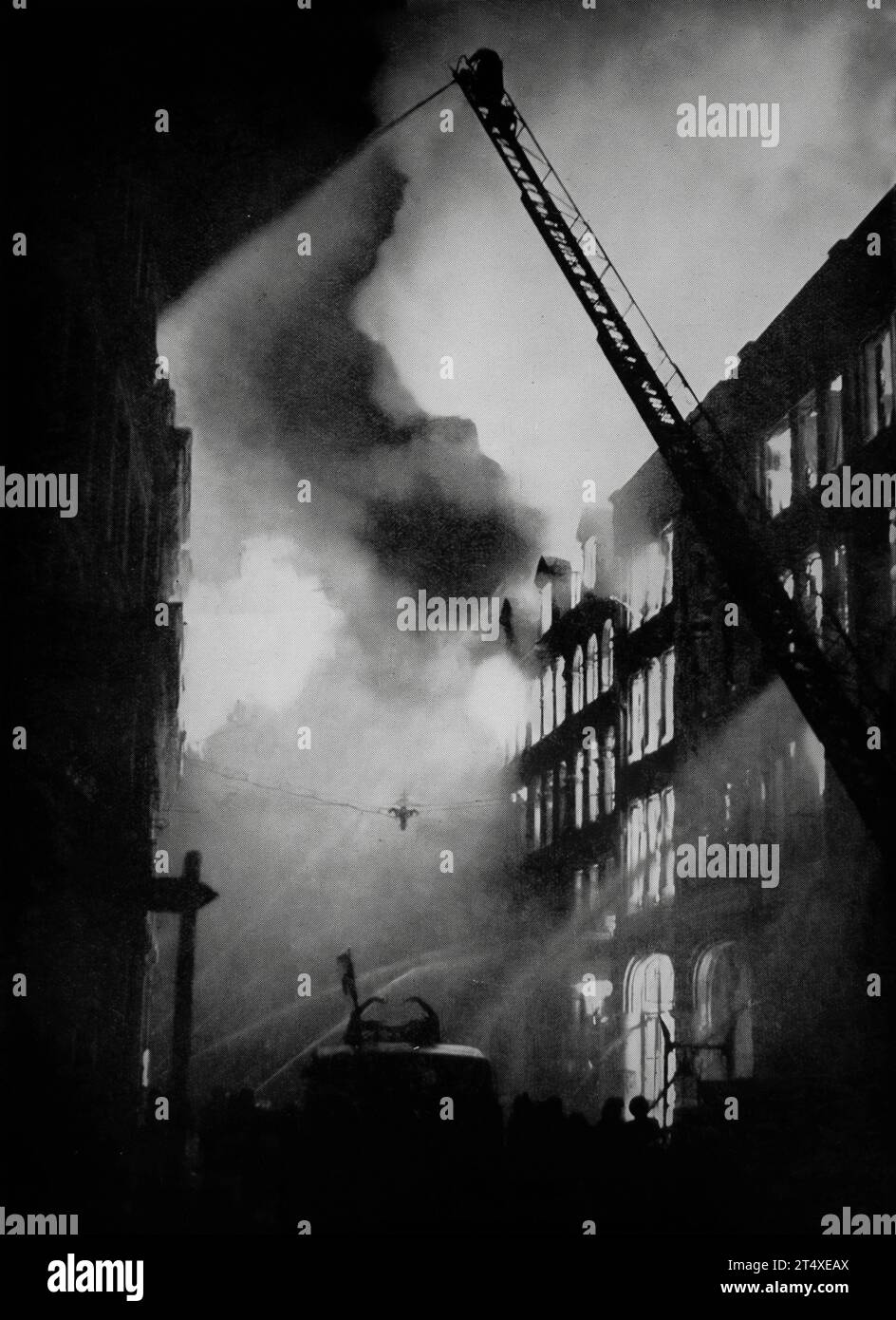 Kurz nach Mitternacht am 21. August 1940 wurden die ersten Bomben von der Luftwaffe auf London, England, abgeworfen, was einen Brand in einem großen Geschäftsgebäude verursachte. Stockfoto