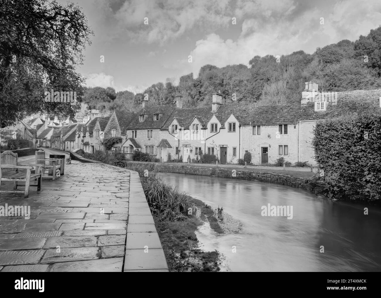 Blick über einen Fluss zu alten Hütten in Castle Combe Stockfoto