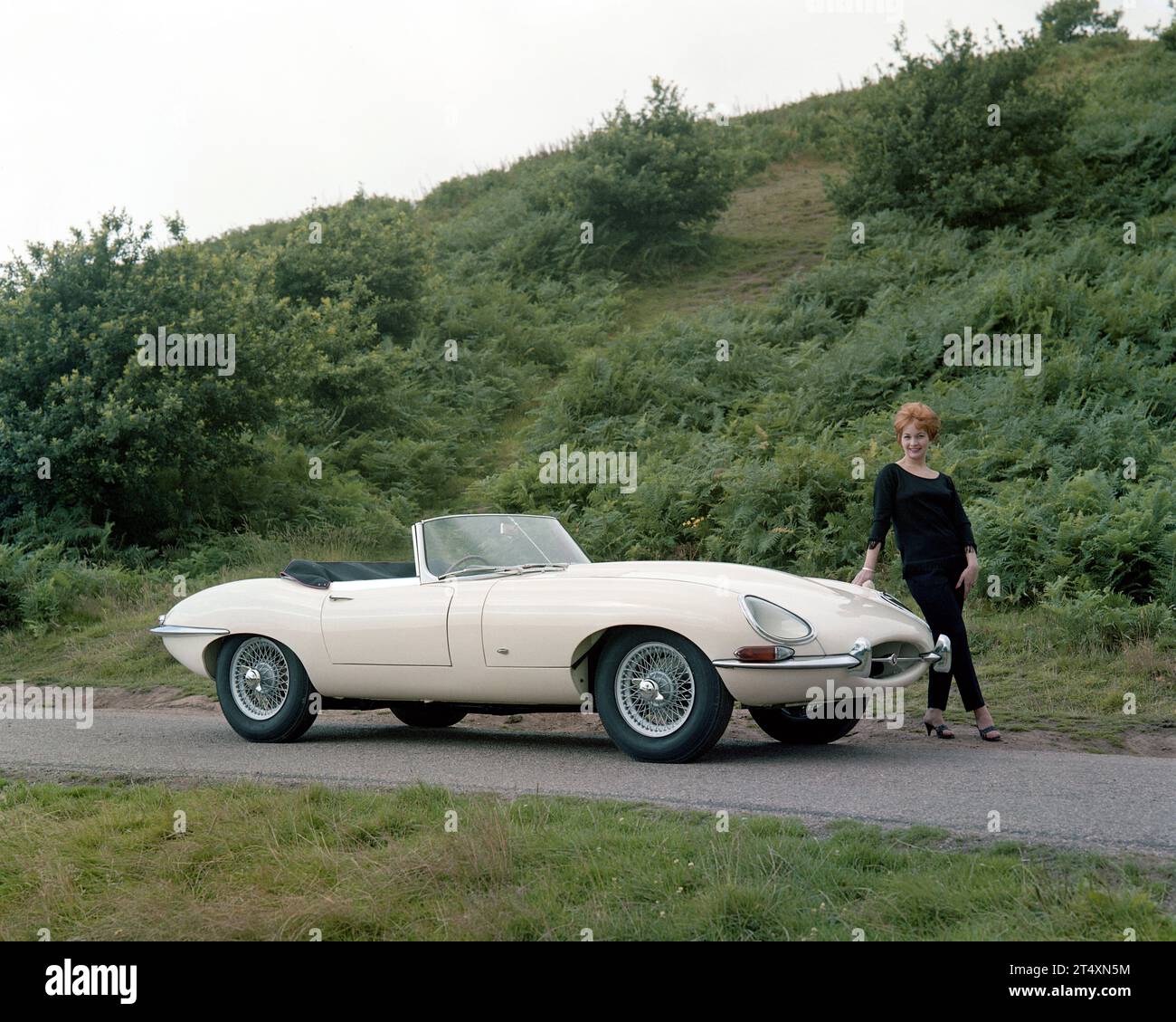 Frühe Werbefoto des Jaguar E-TYPE S1, offener Zweisitzer, 3,8 l, mit Modell in schwarzer Hose und schwarzem Pullover. Im Halesowen Golf Club am 21 Stockfoto