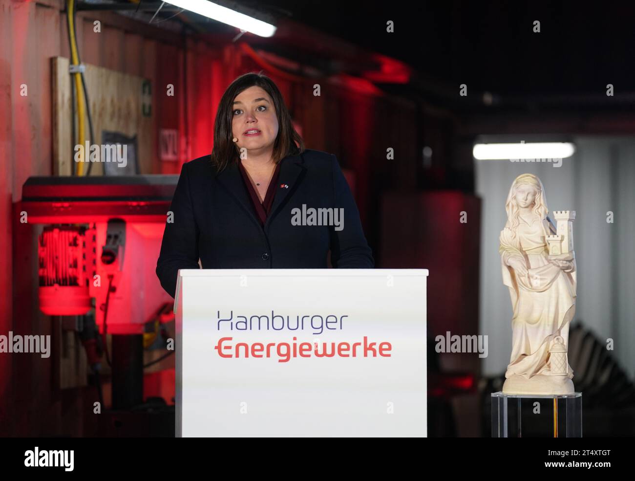 02. November 2023, Hamburg: Katharina Fegebank (Bündnis 90/die Grünen), zweite Bürgermeisterin und Senatorin für Wissenschaft, Forschung und Gleichstellung, spricht neben der Statue der St. Barbara, Schutzpatronin der Bergleute, vor Beginn der Bohrungen für den neuen Hamburger Fernwärmetunnel unter der Elbe. Nach Bergbaubräuchen wurde die Tunnelbohrmaschine für den neuen Fernwärmetunnel unter der Elbe in Hamburg-Waltershof „Hermine“ getauft. Der knapp 1,2 Kilometer lange und begehbare Elbtunnel soll den Energiepark Hafen mit seinem Kombigas verbinden Stockfoto