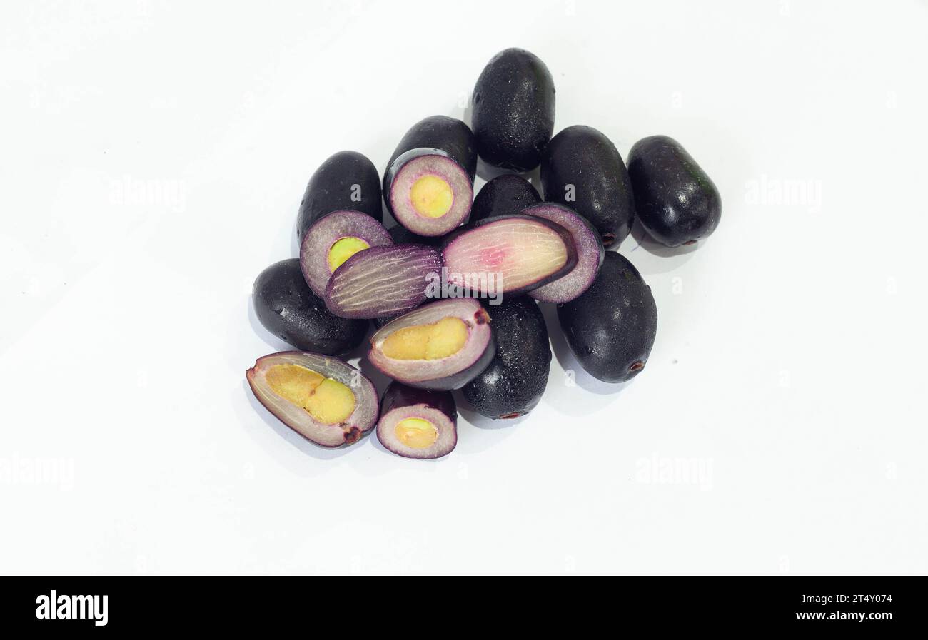 Pflaume, Jamun, Prunus. Das Fleisch ist fest und saftig. Die Schale der Frucht ist glatt und hat eine natürliche, wachsartige Oberfläche, die am Fruchtfleisch haftet. Stockfoto