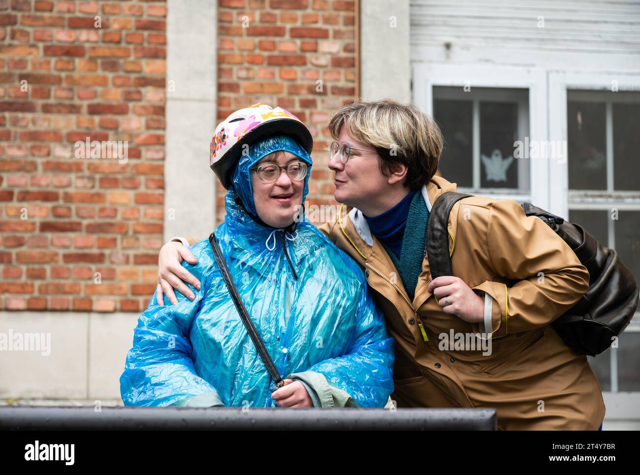 Glücklicher Moment zwischen 41 Jährigen mit einem blauen Regenponcho mit dem Down-Syndrom und ihrem 37 Jährigen Freund Tienen, Flandern, Belgien Stockfoto