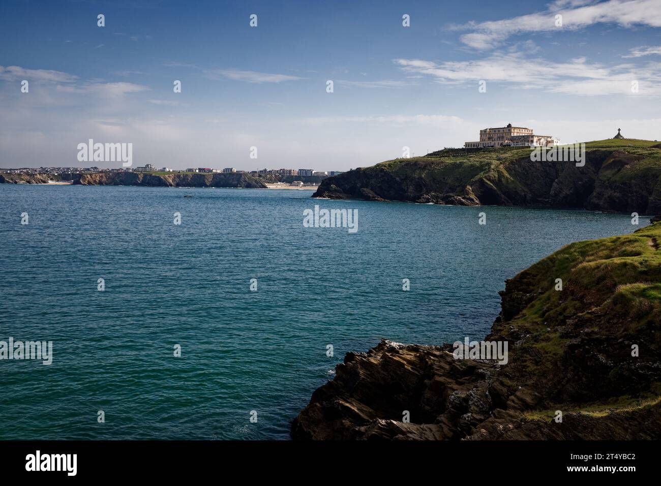 Ein großes Hotel liegt auf einer Landzunge mit Blick auf das blaue Wasser in Newquay Bay, Cornwall. Stockfoto