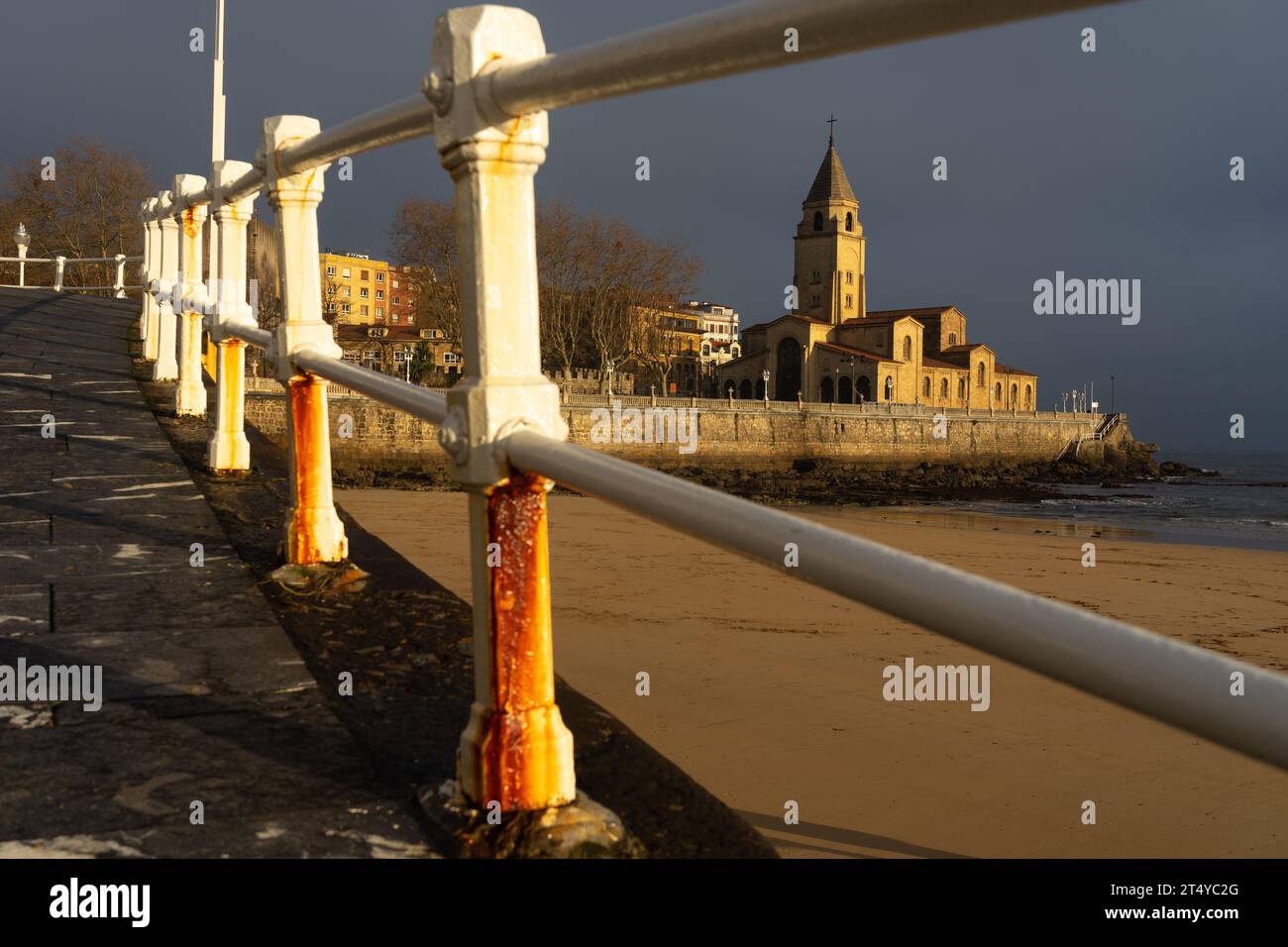 Kirche San Pedro am Strand von San Lorenzo, beleuchtet von der Sonne bei Sonnenaufgang in der Stadt Gijon, Asturien, Spanien Stockfoto