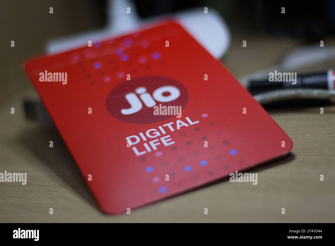 Ein weißes Reliance Jio-Telefon mit einer Auswahl an Kreditkarten daneben Stockfoto
